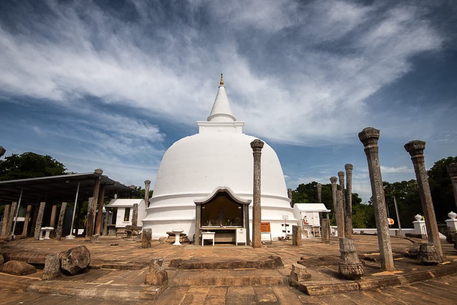 Peaceful surroundings of Lankarama Stupa with elegant stone pillars encircling the stupa structure.
